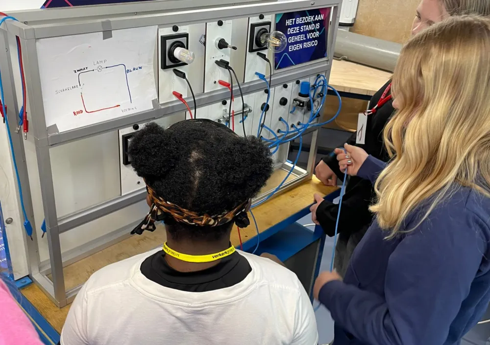 Drie meisjes werken samen aan besturingstechniek in de praktijkruimte